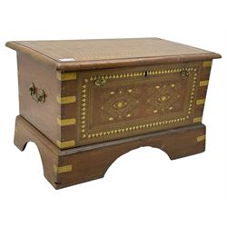 Zanzibar chest, early 20th century, of hardwood construction with brass inlaid foliate and geometric decoration to the lid, fitted interior of multiple carved compartments, with brass strapwork, side handles, and shaped bracket feet