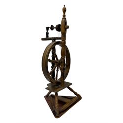 Late 19th century turned beech spinning wheel, upright form with single treadle, triangular base, and a flyer and bobbin assembly surmounted by a turned finial.