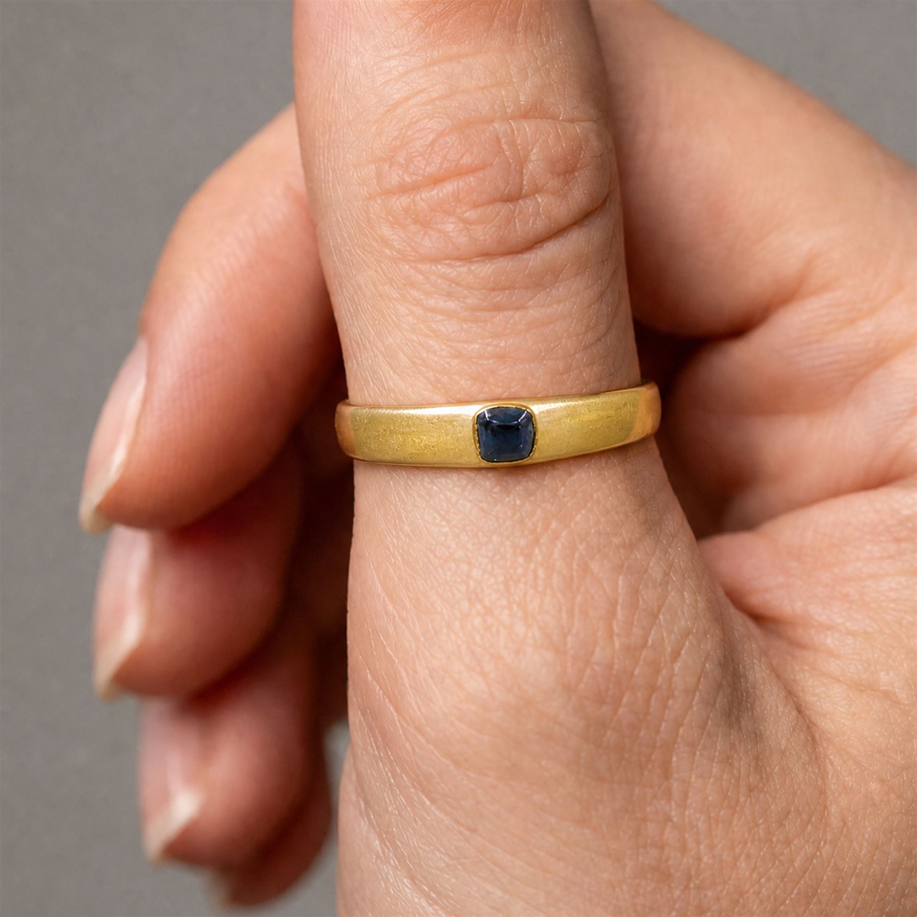 Medieval gold sapphire stirrup ring, circa. 1150-1500, the hoop of ‘D’ shaped cross-section, with raised triangular shaped bezel centred at the apex with a cabochon sapphire
