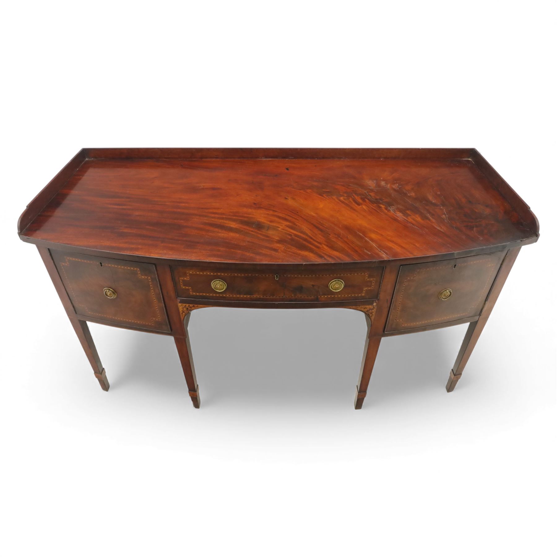  George III mahogany bow-front sideboard, the top with shaped gallery back above one frieze drawers, each outlined with strung inlay, flanked by deep cupboard doors, raised on square tapering legs with spade feet