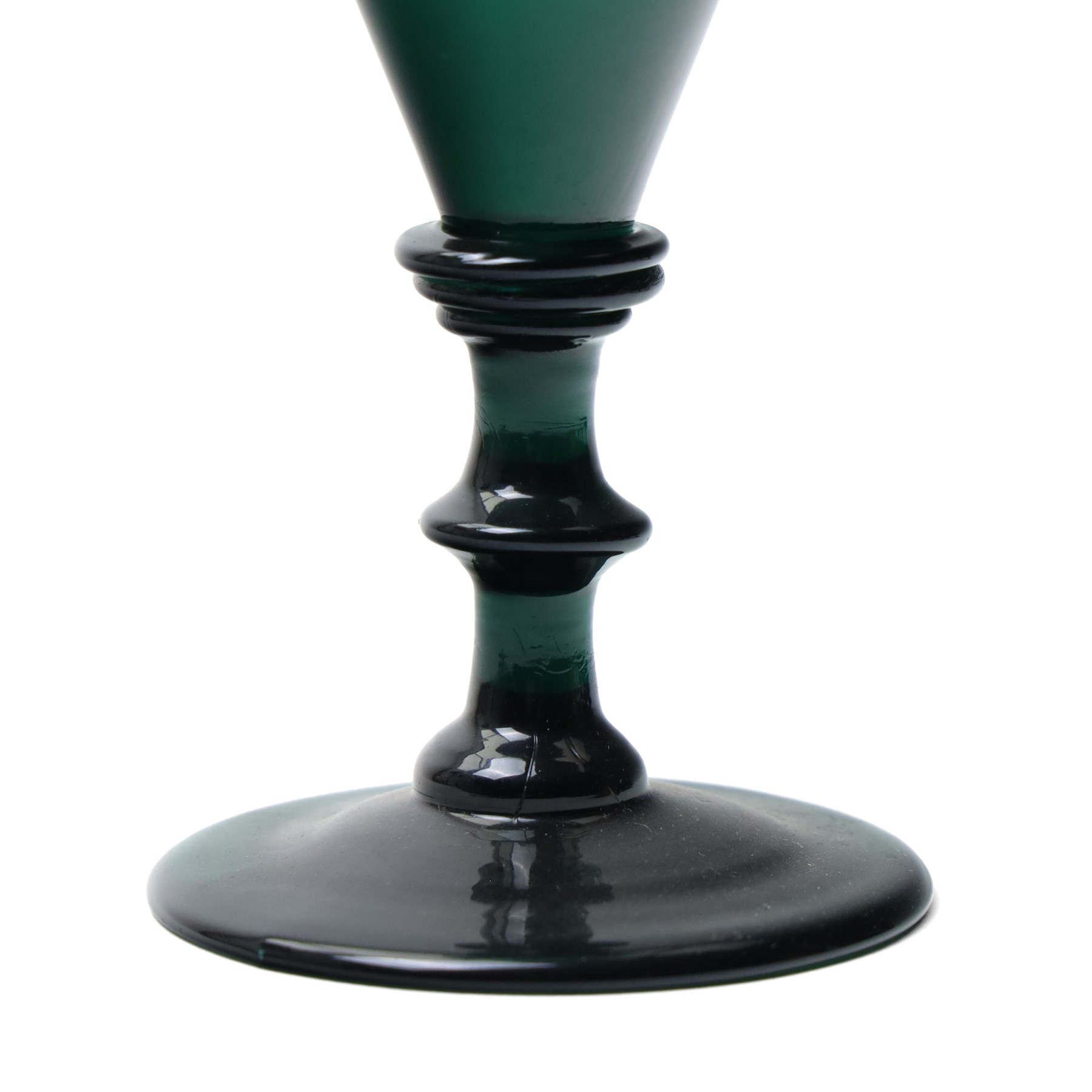 Five green wine glasses of early 19th century design with conical bowls and double knop stems on a circular foot, with pontil marks, pair of green wine glasses with chamfered stems together with an Asprey catalogue of green glass 1740-1840 and two pieces of glass fruit and leaves