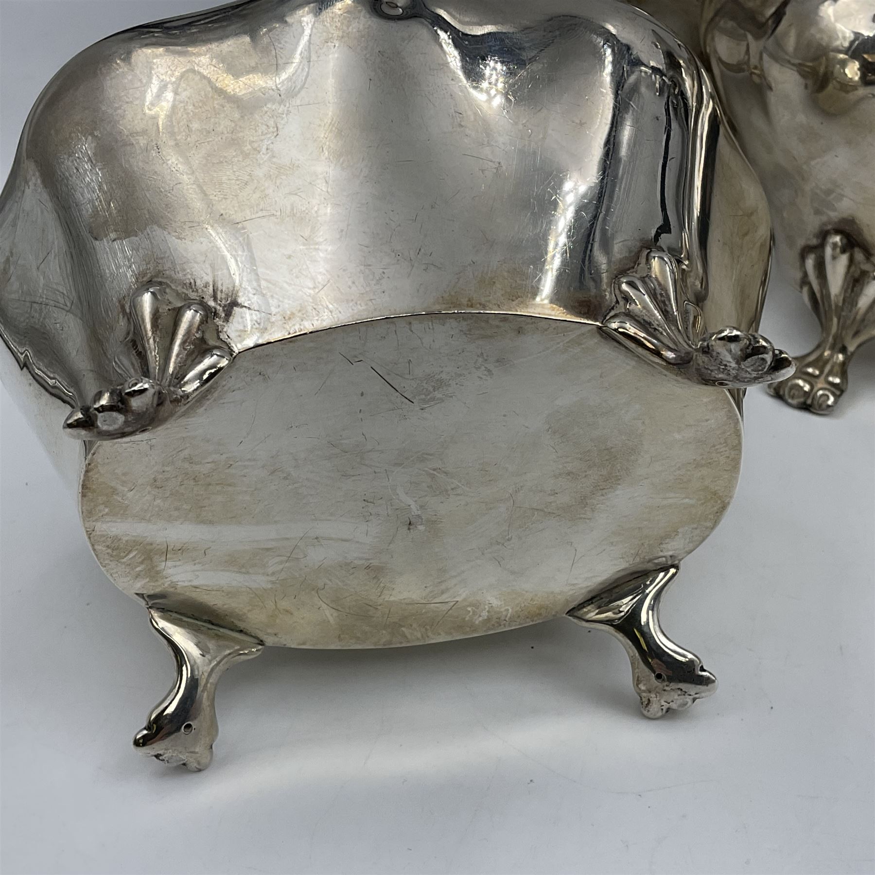 Five piece Edwardian silver tea service, comprising teapot and coffee pot, each with ebonised scroll handle, tea caddy with hinged cover, twin handled open sucrier, and milk jug, each of rounded bombe form, upon four paw feet, hallmarked William Adams Ltd, Birmingham 1904 and 1905, coffee pot H26cm
