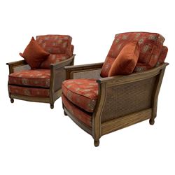Ercol medium elm framed three seat bergere sofa, and pair of matching armchairs upholstered in red fabric