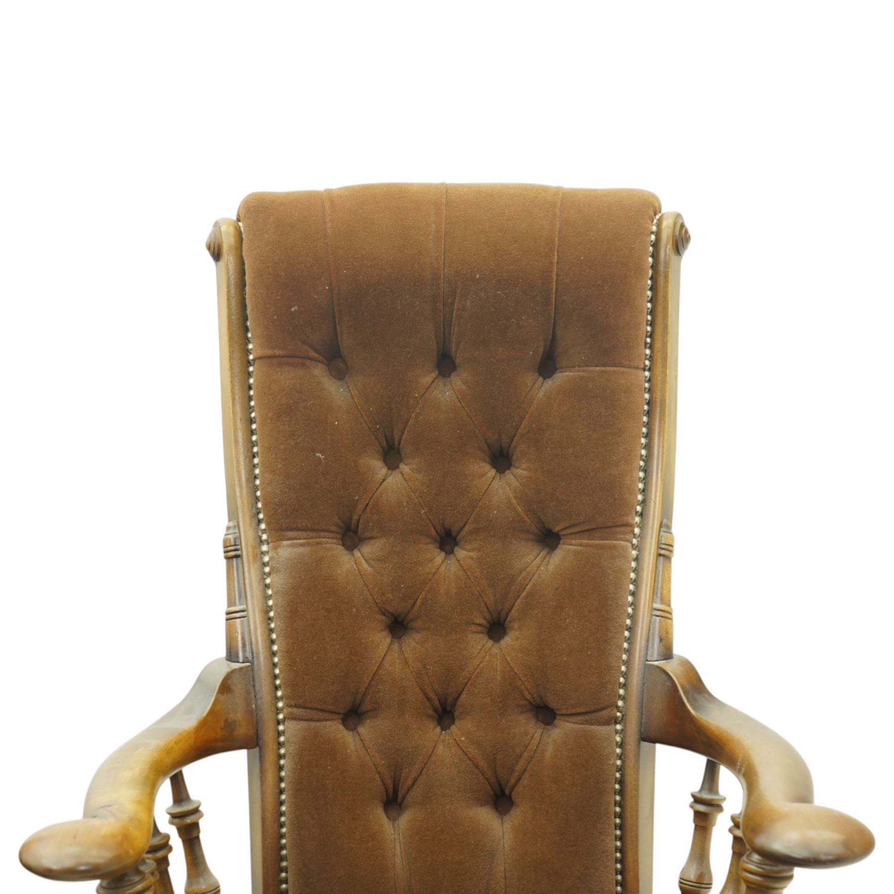 Near pair of late 20th century oak high back armchair, upholstered in brown fabric with buttoned back and close-nailed borders, shaped arms on turned supports, over a stuff-over seat, raised on turned legs united by stretchers