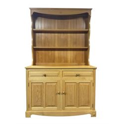 Unicornman - light oak dresser, the shaped cresting rail carved with Yorkshire rose over two heights plate rack, the panelled lower section fitted with two drawers and two cupboards, carved with unicorn signature, by Geoff Gell, Coxwold
