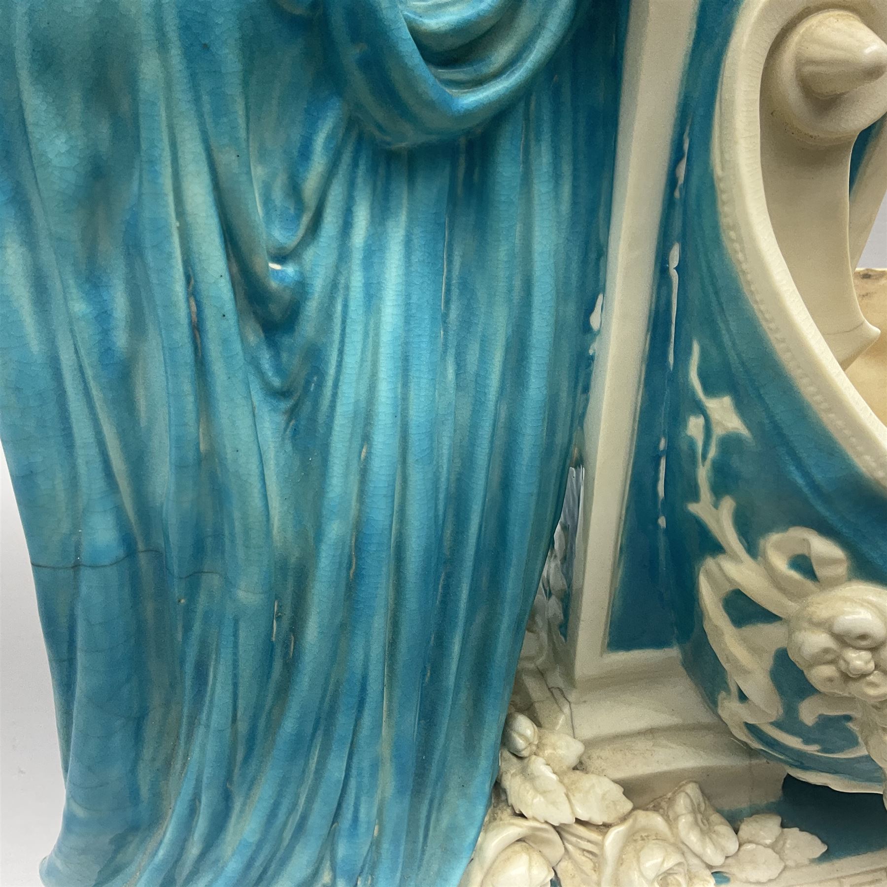 Rare 19th century Minton turquoise glaze majolica 'The Reader' flower holder, after Albert Carrier-Belleuse, modeled as a maiden in classical drapery reading whilst leaning against the pillar back of the helmet shaped cistern detailed with a caryatid and floral swags, the whole upon an oval plinth with Greek key border, with impressed marks beneath, H44cm