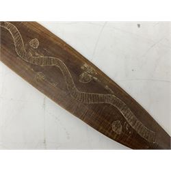Australian aboriginal woomera spear thrower incised/carved with a wavy line and dots L69cm; and two boomerangs, one with carved geometric decoration (3)