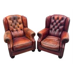 Tetrad - pair of 'Oskar' wingback armchairs, deep-buttoned oxblood leather upholstery with rolled arms and brass stud trim, raised on turned and reed moulded feet