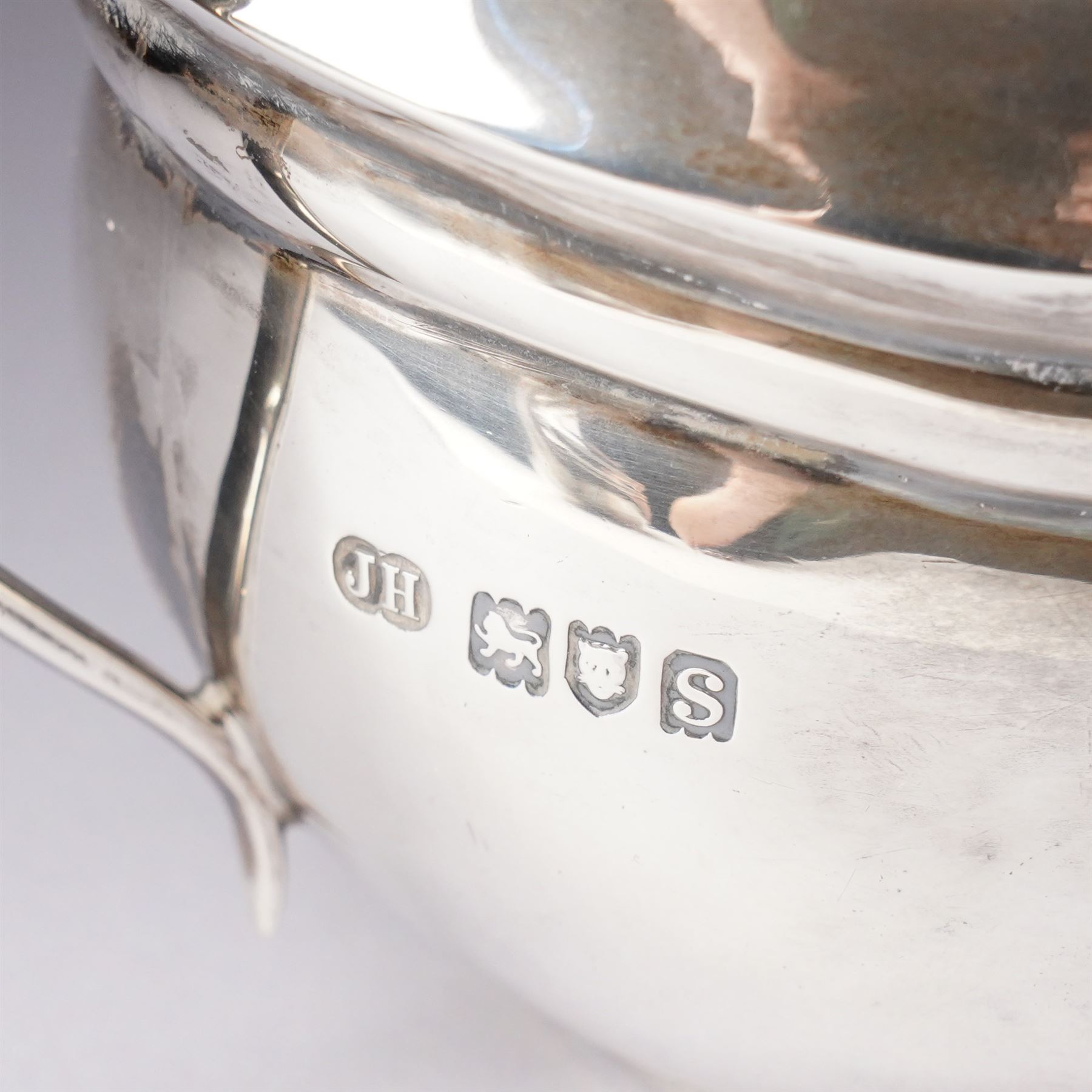 Silver three piece tea set of oval form, the teapot with ebonised handle and lift London 1913 Maker John Hunt and a pair of Victorian silver sugar tongs