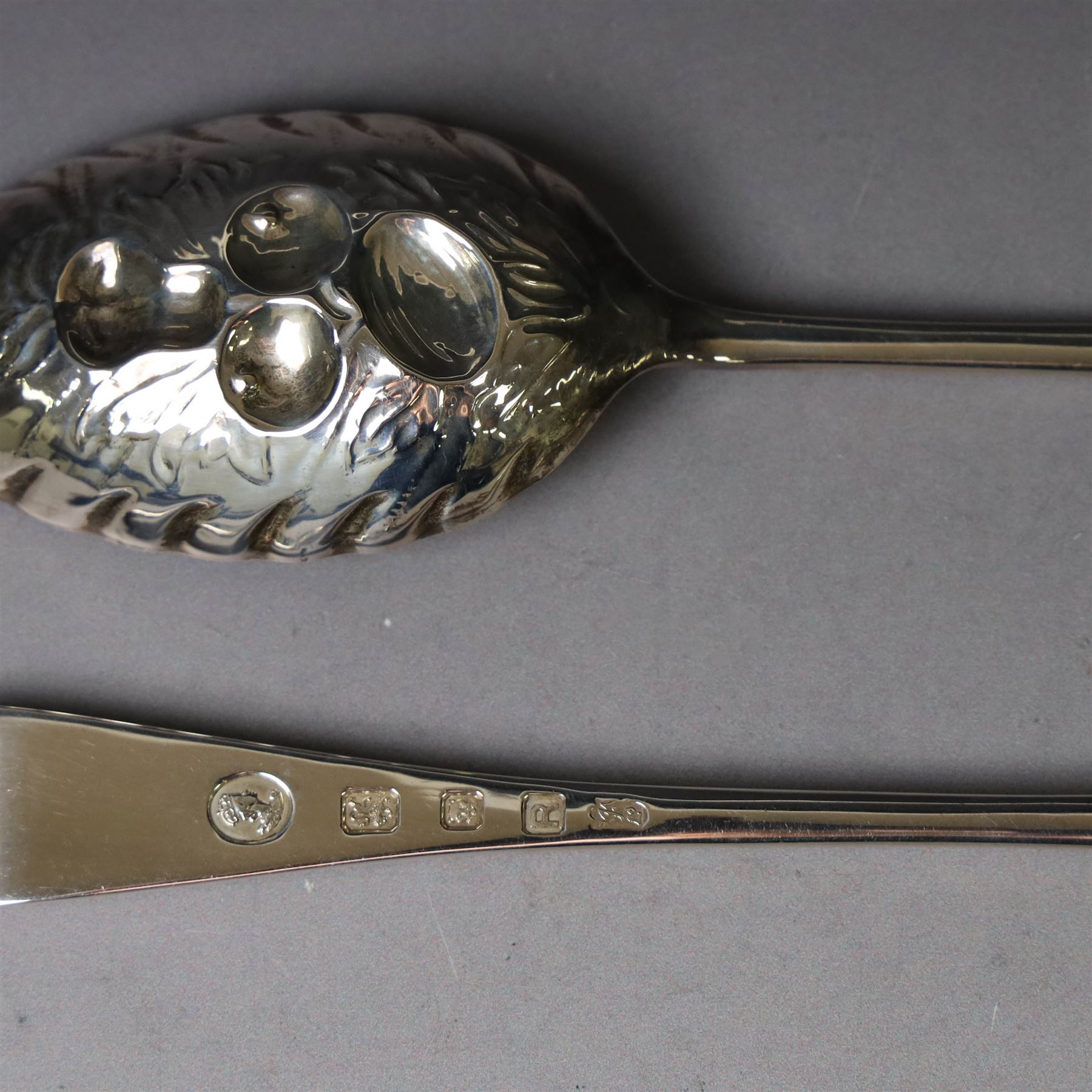Mid 20th century silver berry spoons, each with gilt bowls embossed with fruit, with Queen Elizabeth II Coronation hallmark for C J Vander Ltd, London 1952, L22cmcm