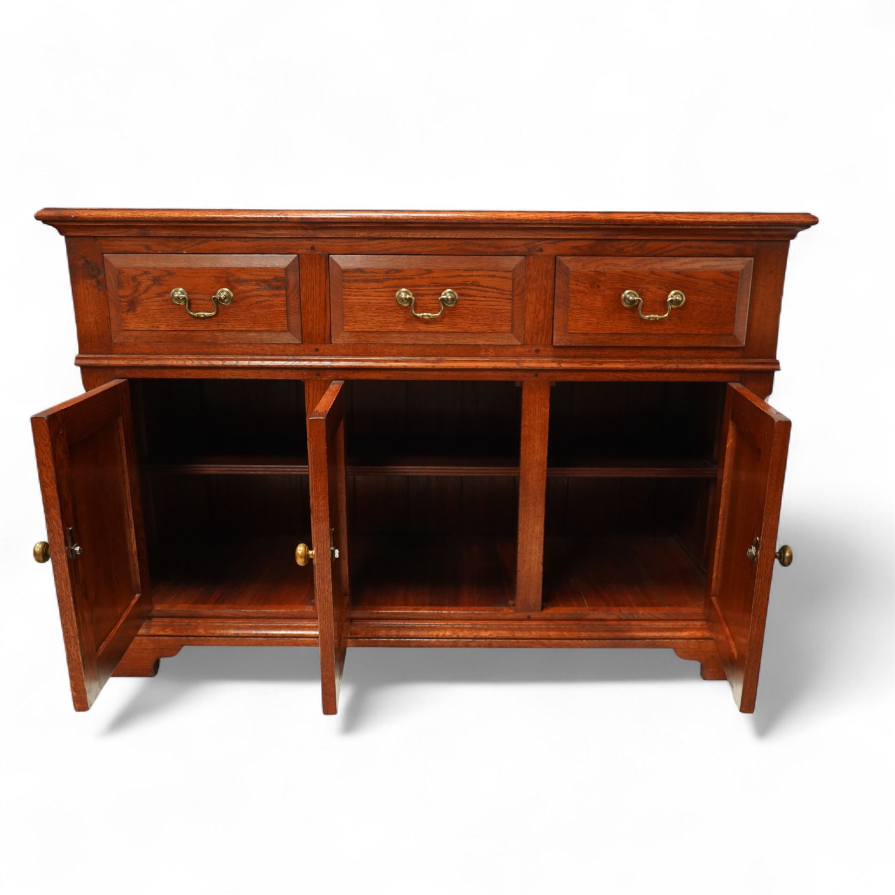 20th-century oak side cabinet, rectangular top above an arrangement of three drawers and three panelled cupboard doors, fitted with brass knobs, raised on bracket feet  