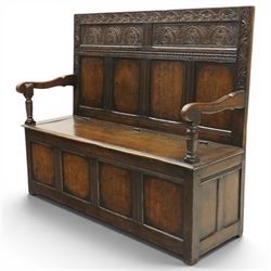Victorian Jacobean Revival carved oak settle or hall bench with box seat, the cresting rail carved with repeating lunette motifs with acanthus and rosette decoration, over four back panels and hinged box seat, the panelled base raised on stile supports