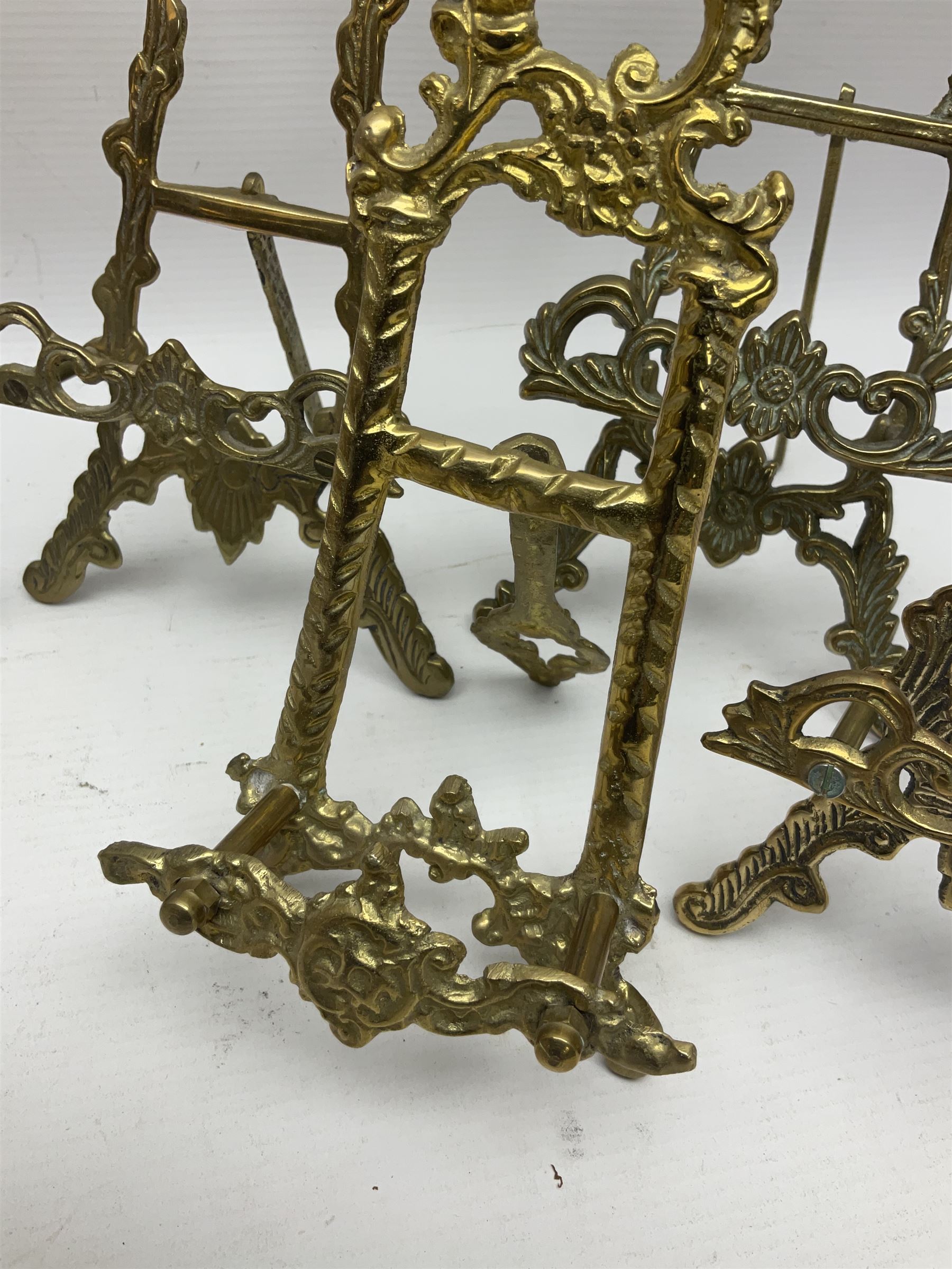 Nine ornate cast brass easel stands of various sizes, H24cm