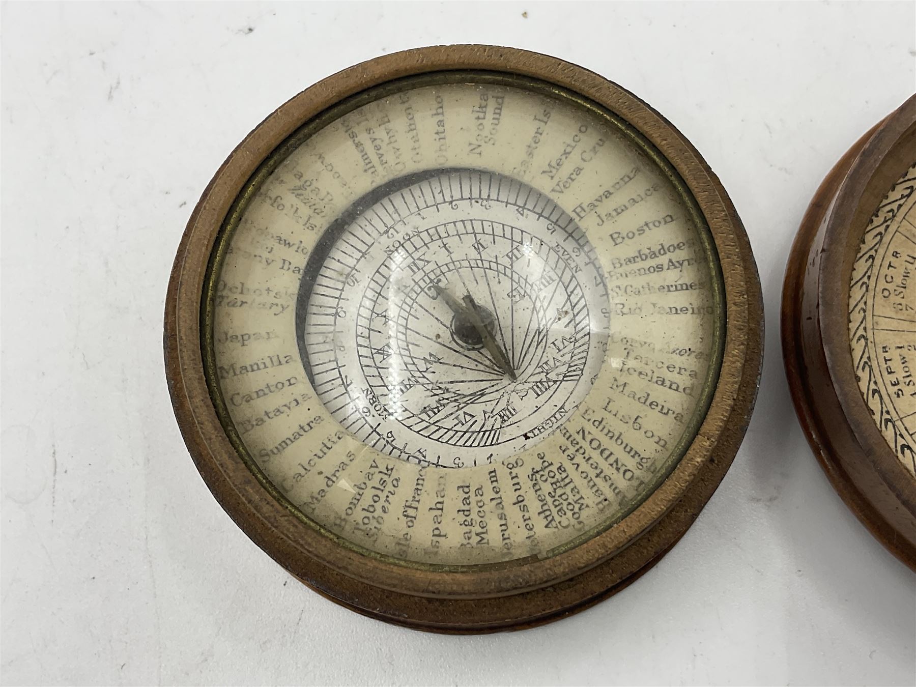 19th century pocket sundial compass pantochronometer, central sun dial pivoting with angled gnomon, within a broad enamelled band, listing world cities, paper calendar label to cover
