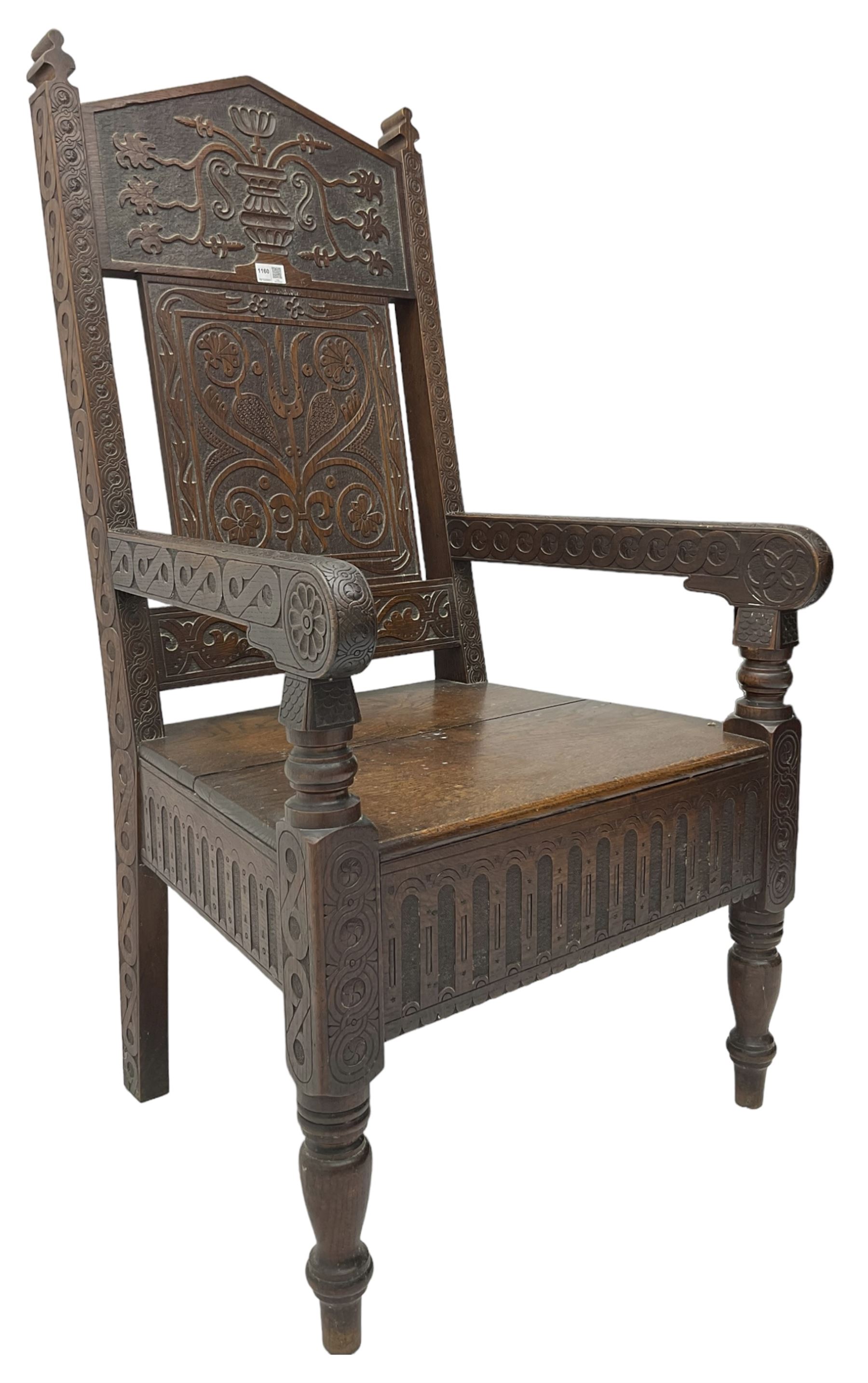 17th century design oak wainscot chair, the back profusely carved with scrolling foliate motifs, the arms carved with repeating guilloche decoration over an arcade apron and turned supports