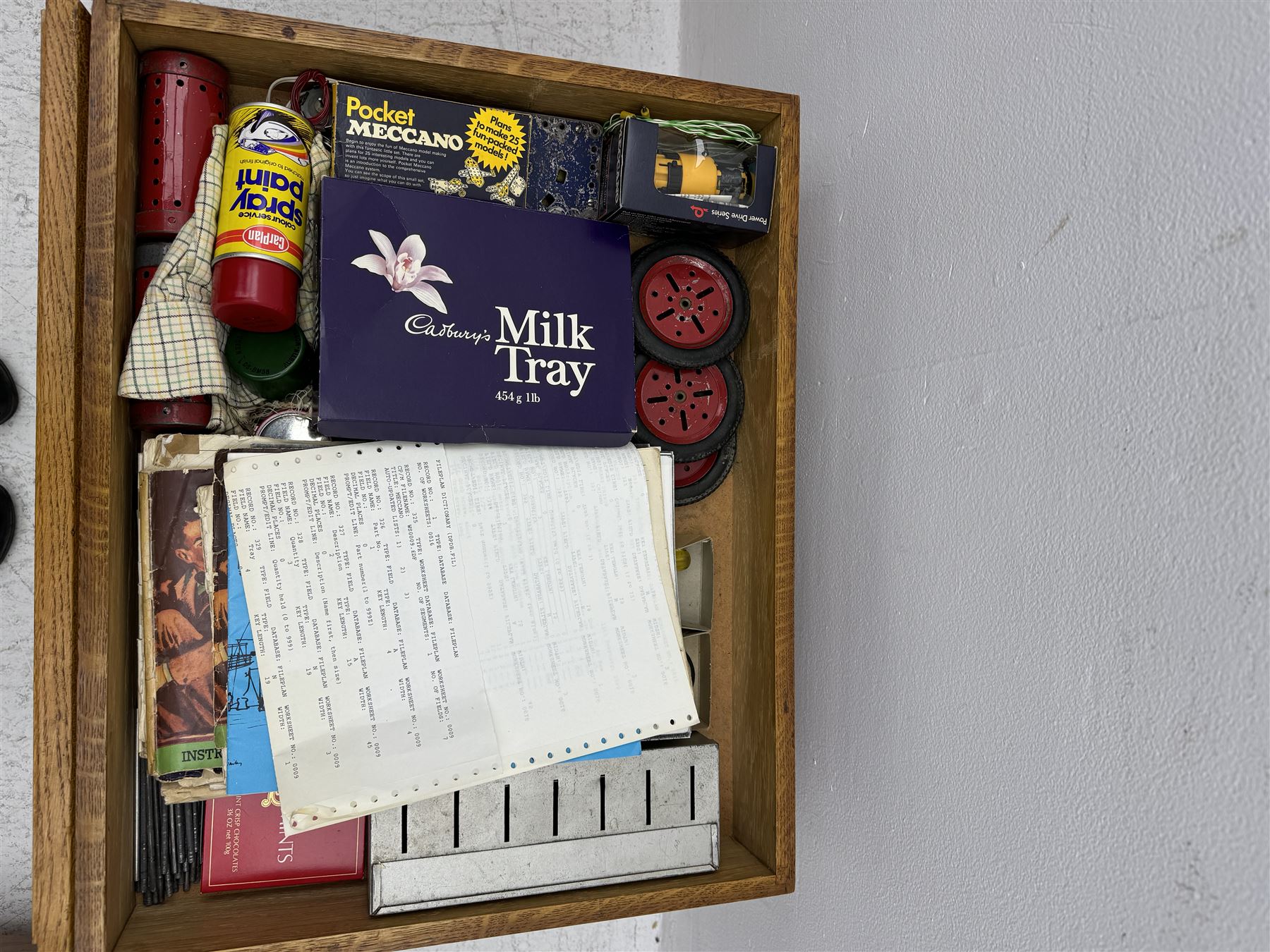 Large collection of Meccano, including perforated strips, wheels, cogs, nuts and bolts, various Meccano instruction manuals and magazines, all housed within a modified wooden box, with three tiered compartmentalised sections and upon four twist legs, box H60cm
