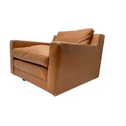 Mid-20th century armchair, upholstered in tan leather with loose cushions, on castors