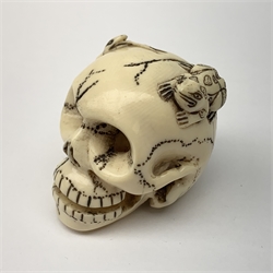 Japanese Meiji carved ivory netsuke, modelled as a skull, the top carved with two toads, and script and signature to reverse, L5cm, H4cm   