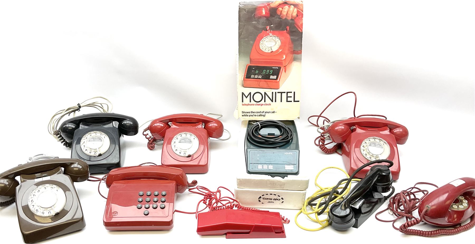 Collection of vintage telephones, including dial and button phones, together with a Monitel telephone charge clock and additional black handset. 