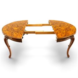 Dutch design figured walnut extending dining table, the shaped circular extending top with book-matched veneer and moulded edge, shaped banded frieze over scroll-moulded lower rail, raised on C-scroll carved cabriole supports with pad feet, with additional leaf