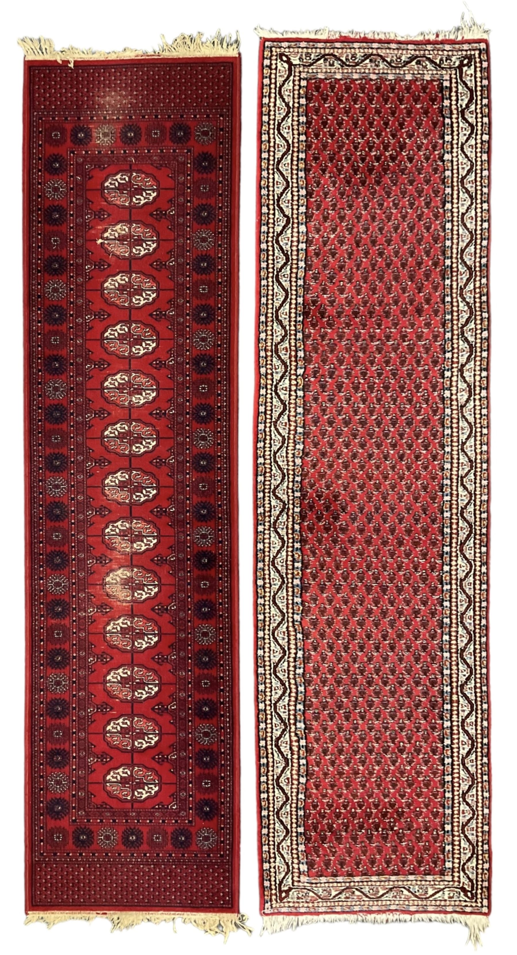 Persian design red ground runner, the field decorated with repeating Boteh motifs, five-band border (277cm x 74cm); Bokhara design red ground rug, decorated with a single row of Gul motifs (272cm x 69cm)