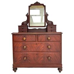 Victorian scumbled pine dressing chest, raised swing mirror in moulded frame with scrolled carved pediment, foliage S-scroll carved supports over trinket drawers, moulded rectangular top with rounded corners over two short and two long drawers, skirted base on turned feet, scumbled to resemble mahogany 