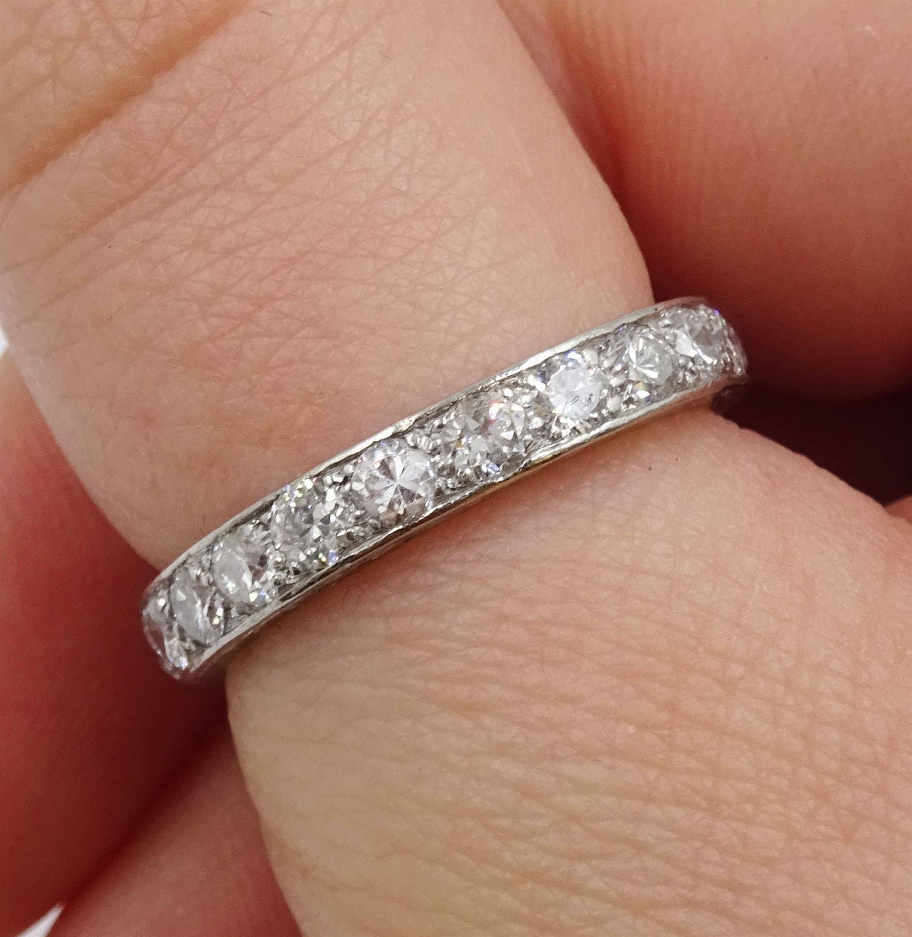 Early-mid 20th century platinum old cut diamond full eternity ring, twenty two diamonds of approx 0.06 carat, total diamond weight approx 1.30 carat, engraved decoration to the sides