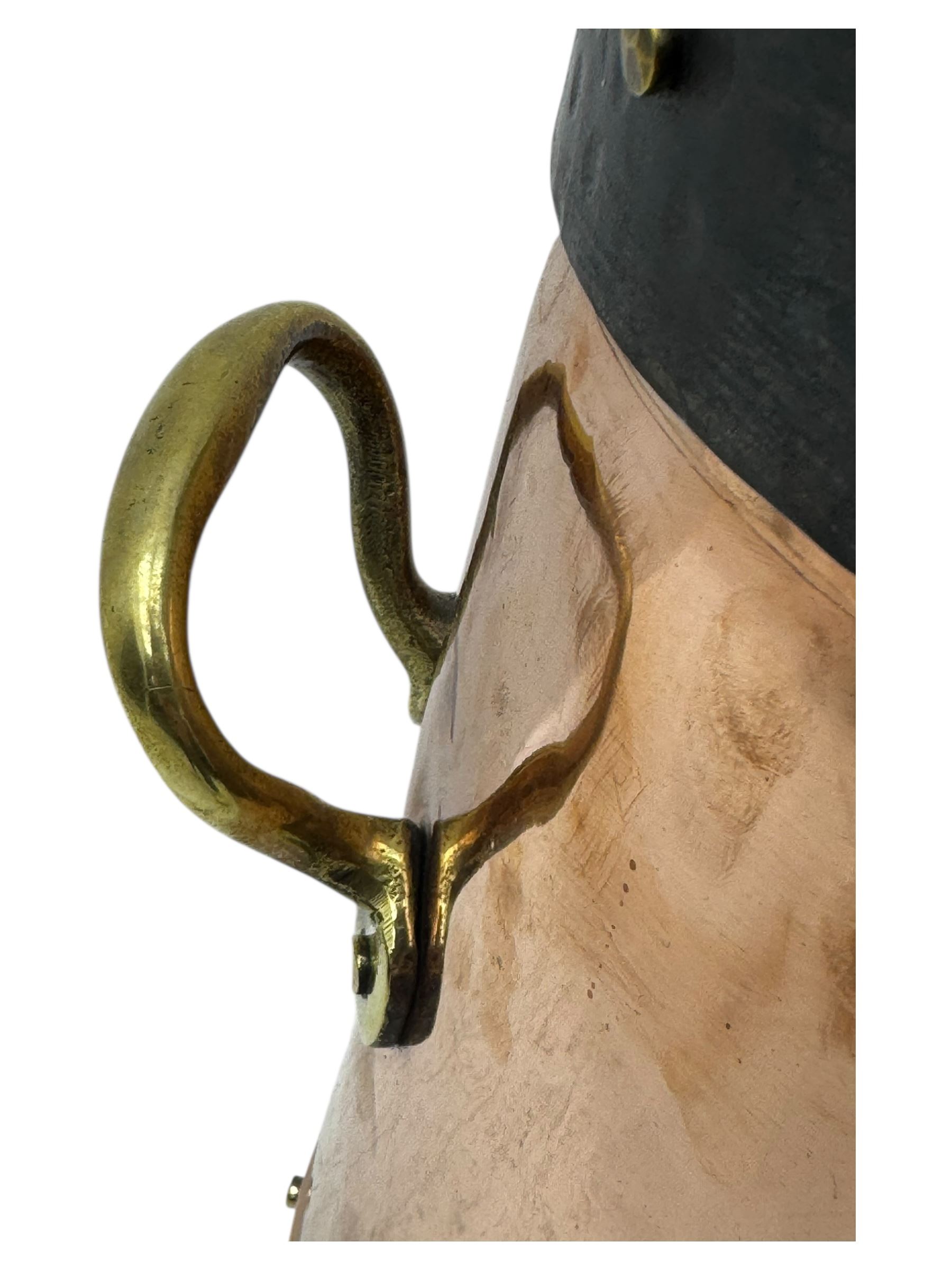 20th century copper milk churn, of tapering cylindrical form with applied brass twin handles and darkened banded rim and base