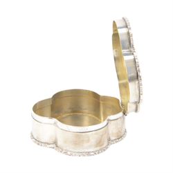 Early 20th century silver trinket box, of quatrefoil form, with shaped rim and engine turned decoration to cover, with vacant circular cartouche, hallmarked Deakin & Francis, Birmingham 1917 or 1942, H3cm, W8.5cm, together with an early 20th century silver swing handled sugar basket, with gilt interior, hallmarked Levi & Salaman, Birmingham 1918