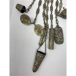 A Victorian metal chatelaine, the scrolling pierced and mask and putti decorated clip suspending seven chains with accessories, to include 
pencil holder, ivory paged aide memoire, and winding tape measure, each with relief foliate decoration, L40cm. 