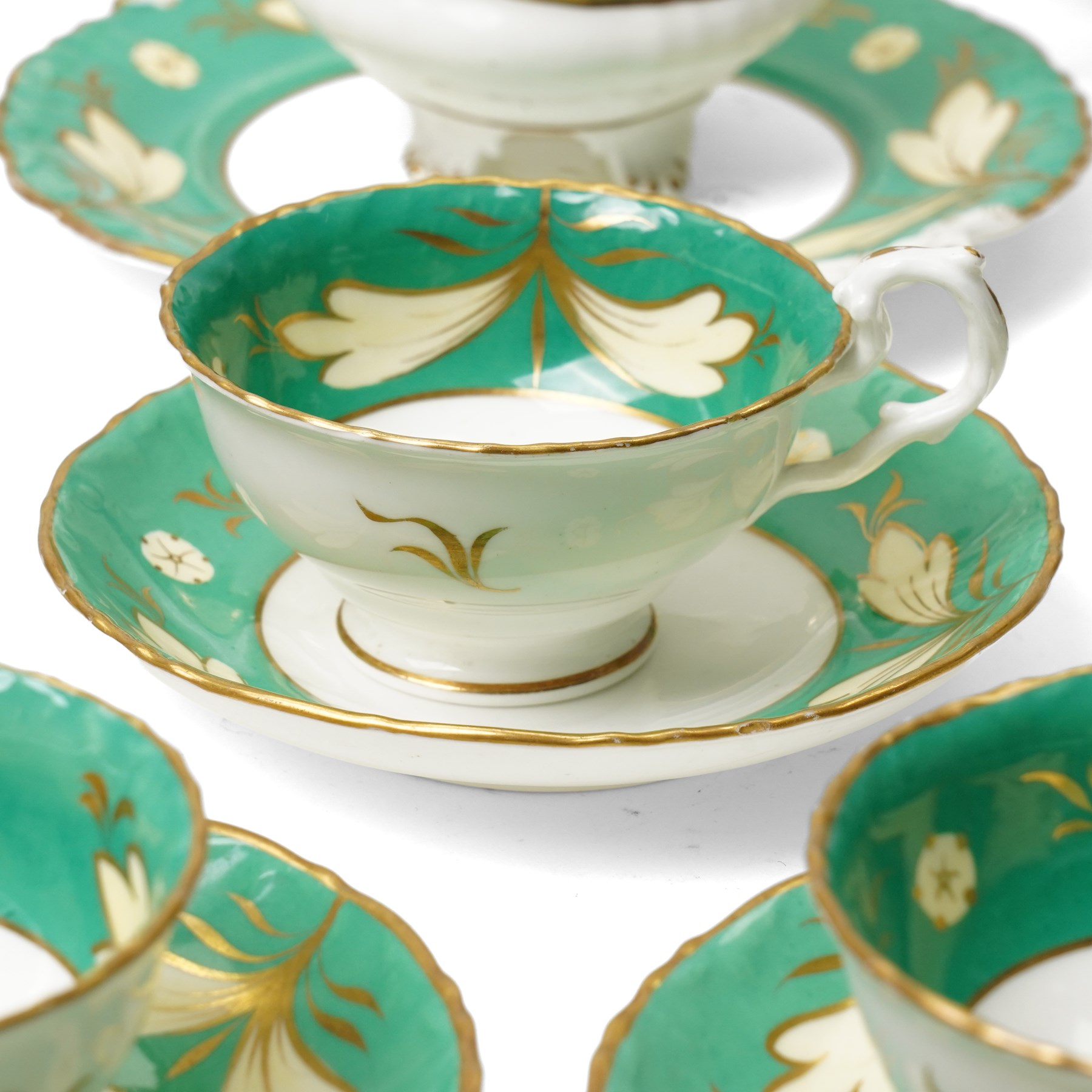 19th century porcelain tea service decorated with a border pattern of yellow leaves on a green ground comprising twelve cups and saucers, tea pot, sucrier and cover, milk jug, slop bowl and three plates, pattern number 5850