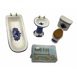 Georgian style wooden double fronted three-storey dolls house with pale blue stucco finish under a faux tiled roof with two chimney stacks, the double hinged front opening to reveal six fully decorated rooms with floor coverings, central staircase, porcelain fitted bathroom, kitchen with deep white sink and Aga cooker, electric lighting with adaptor, fully furnished with French style and other furniture, grand piano etc, and comprehensive range of accessories H82cm W61cm D31cm