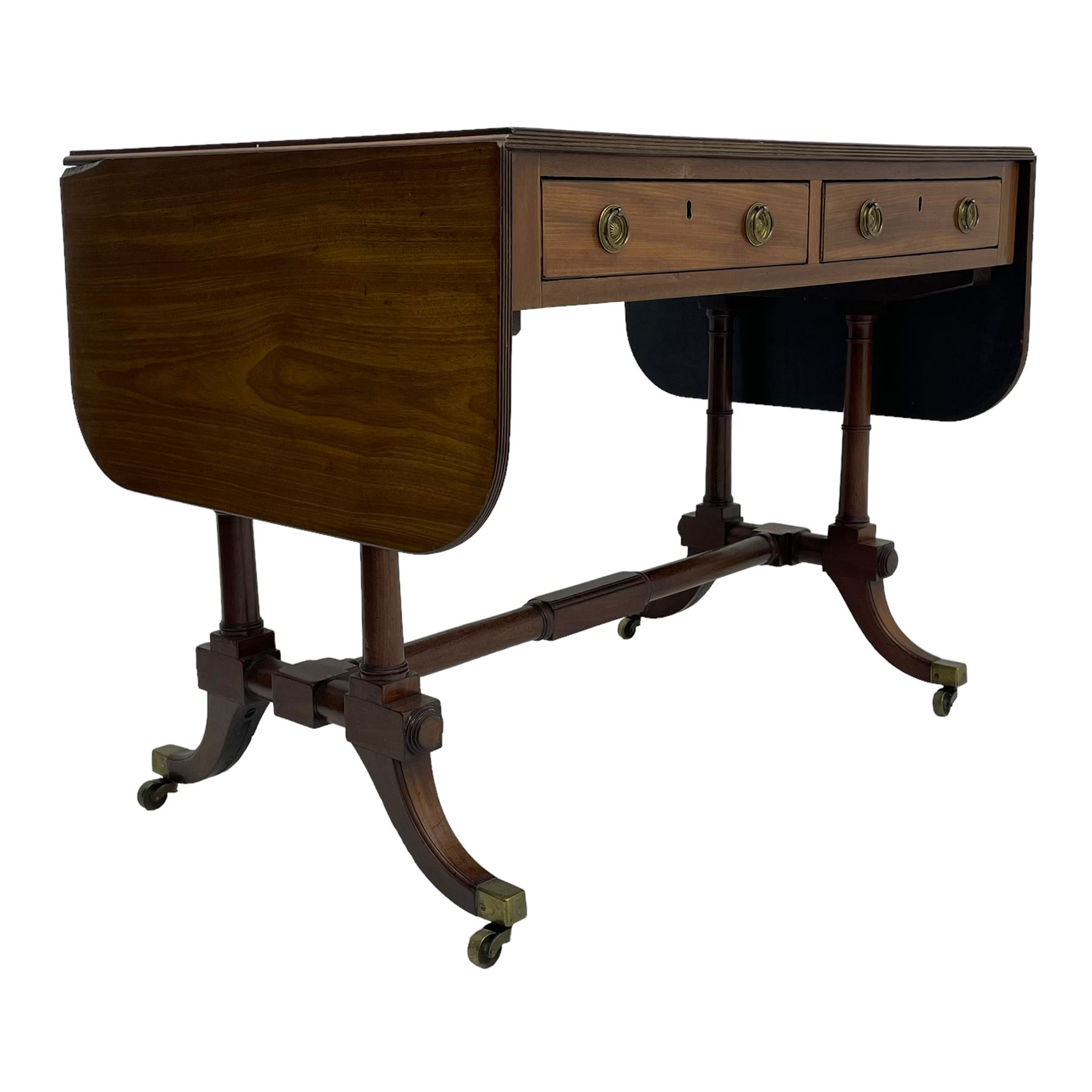 George III mahogany sofa table, rectangular drop-leaf top with reed moulded edge and rounded corners, fitted with two frieze drawers and two opposing false drawers, quadruple collar turned pillar supports on turned and block platforms, splayed and moulded supports with brass cups and castors 