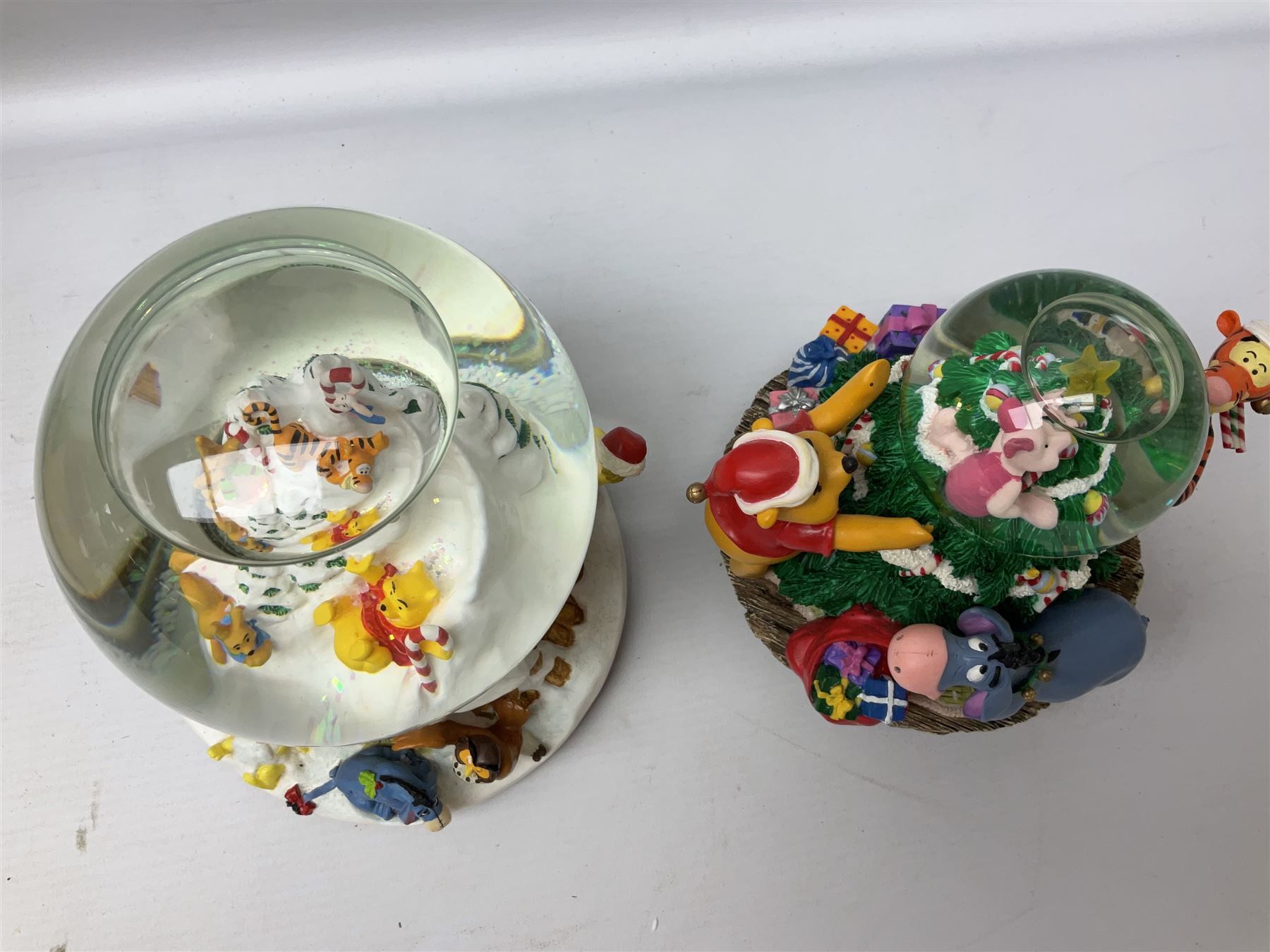 Six Disney Winnie the Pooh Christmas snow globes, comprising large Mr Christmas Holiday Snowfall, An Enchanted Christmas, It's A Small World Christmas 1994,  Tree Trimming, 1995 Christmas At Our House and Christmas Band Concert, together with Mr Christmas Holiday Go Round, all with boxes (7)