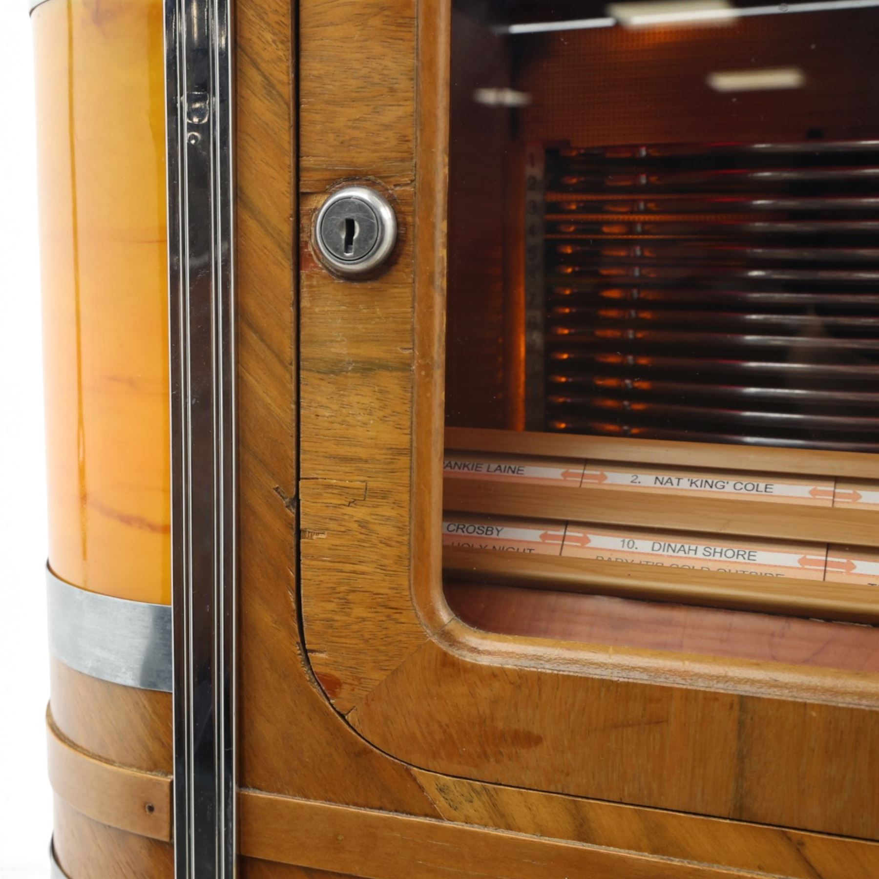 Rudolf Wurlitzer Company - Model 616 'Simplex' 1937 jukebox, figured walnut veneered cabinet with illuminated red and amber side panels enclosed by chromed uprights, glazed upper record compartment, cast Art Deco speaker grille, coin-operated push-button selection panel with circular title index, raised on a moulded base