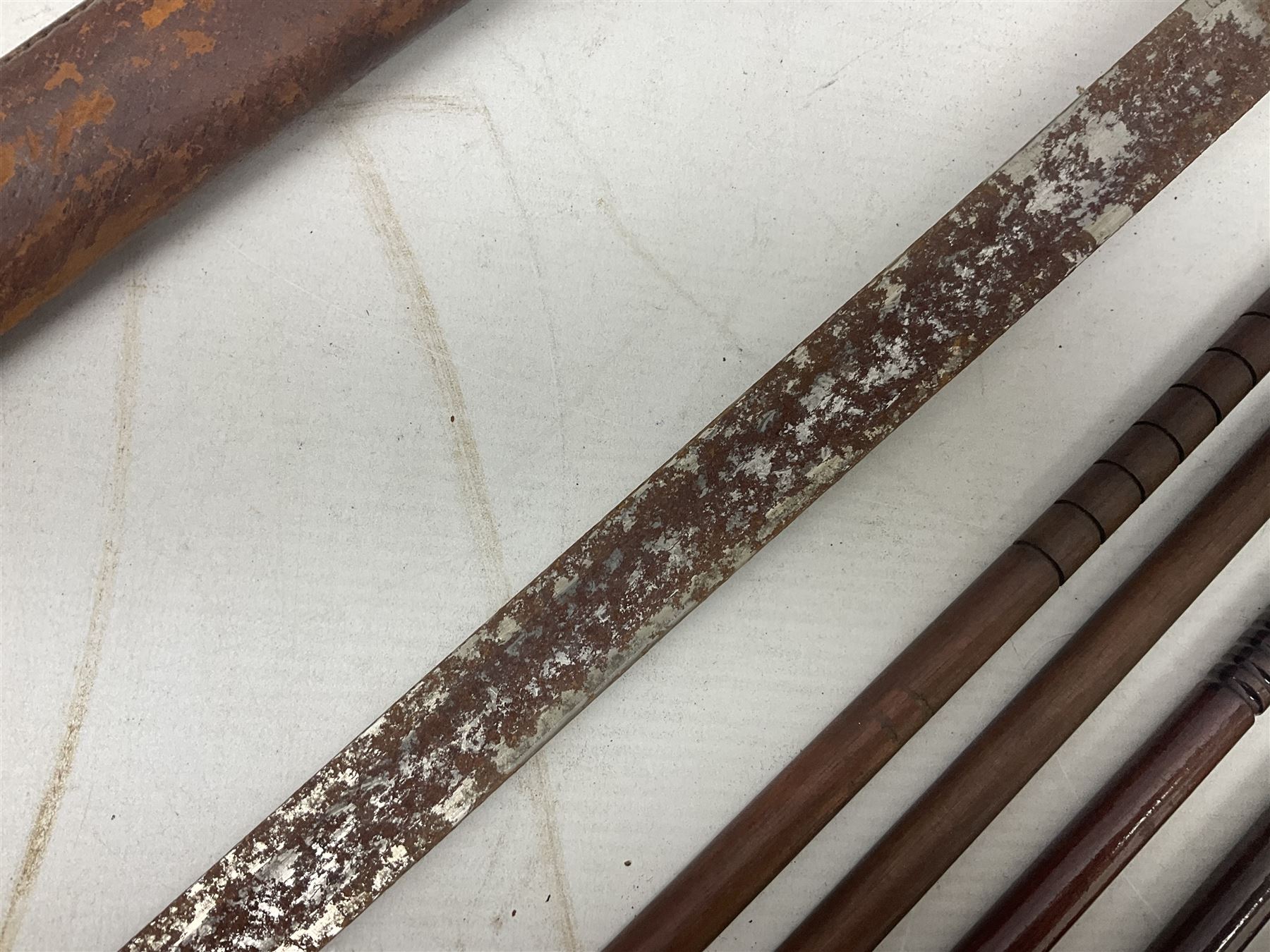 George V 1897 pattern Infantry officers sword, the 82cm single fullered blade with traces of etched detail and George V crown cipher, the ricasso marked Hawksworth Sheffield, pierced half basket hilt with George V cypher, wire-bound fish-skin grip with brass pommel and backstrap; in leather scabbard L102cm overall; together with two sectional gun cleaning rods; swagger stick made of leather strips etc