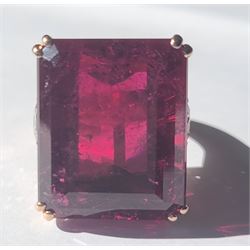 Rose gold rubellite tourmaline and diamond ring, the central octagonal step cut tourmaline of 43.25 carat, with a round brilliant cut diamond set either side and diamond set shoulders by Judith Crowe, hallmarked 9ct, the two large side diamonds total 2.10 carat, with World Gemological Institute report