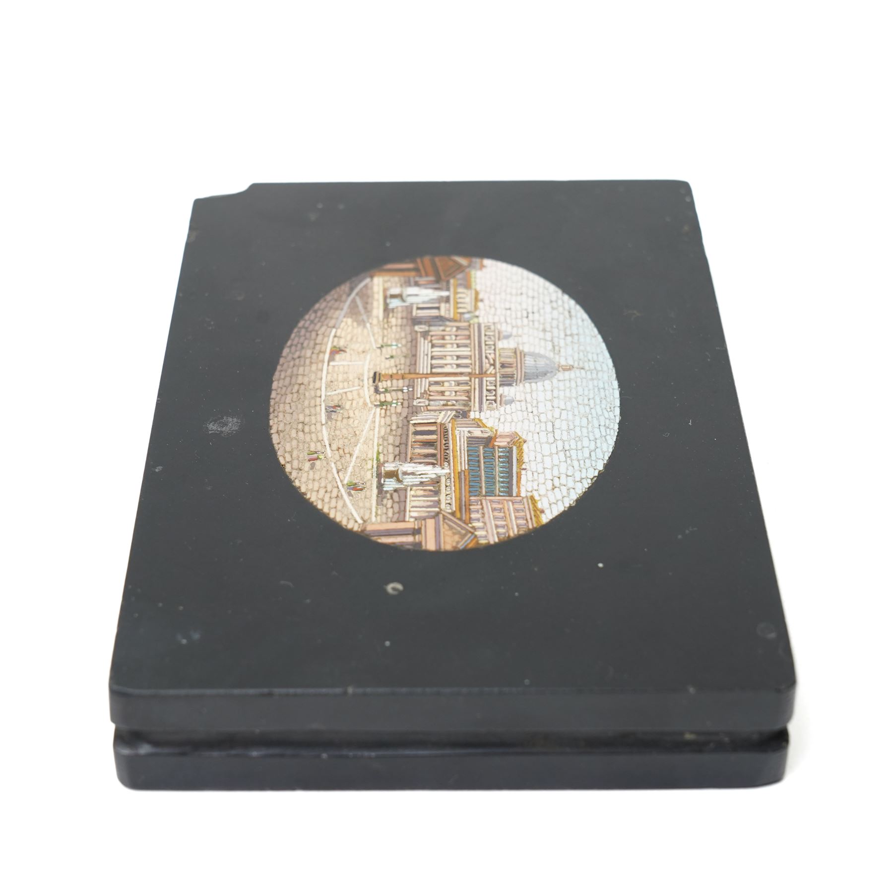 19th-century Italian Grand Tour micromosaic paperweight, the rectangular slab of polished Nero Belgio black marble inset with an oval micromosaic panel finely composed in minute tesserae, depicting a classical architectural view evocative of ancient Rome, centred by a triumphal column and flanked by monumental buildings, 14cm x 9.5cm