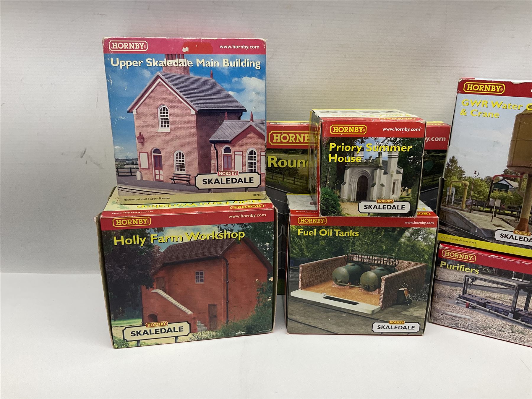 Hornby '00' gauge - nineteen Skaledale trackside buildings/accessories including R8542 Holly Farm Workshop, R9671 GWR Water Column and Crane, R8716 Upper Skaledale Main Building, R8657 Roundabout, R8993 Water Cleansing Tank, R8709 Fuel Oil Tanks, R8741 Purifiers, R9531 Magna Waiting Room etc; all but one boxed (19)