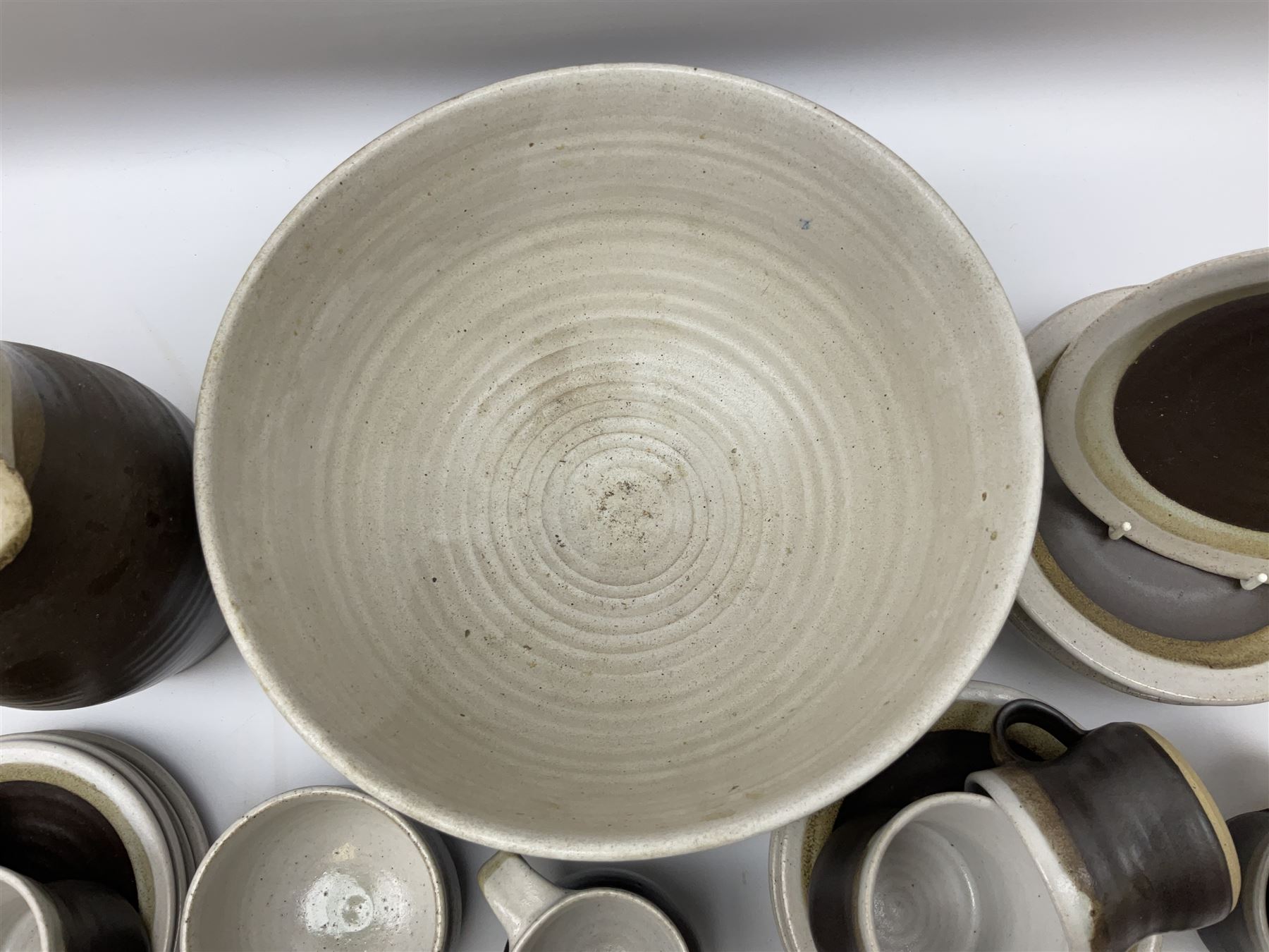 Marianne De Trey (British 1913-2016) stoneware coffee service for twelve, together with a large deep stoneware footed bowl and ladle with wood handle, all decorated in Manganese 'Pattern 1' with impressed shell marks, bowl D27cm