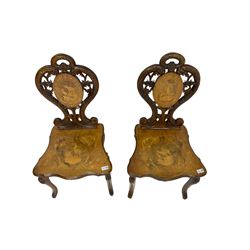 Pair 19th century Black Forest type inlaid hall chairs,  the shaped and pierced back carved with scales and flower heads, inlaid with hunting scenes, on cabriole supports