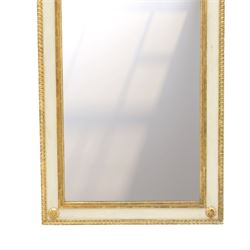 Neoclassical design pair of cream painted and gilt pier mirrors, projecting moulded cornices above frieze panels decorated with ribbon-tied musical trophies, rectangular plates within beaded slips, the outer frames with repeating leaf borders and flowerhead roundels
