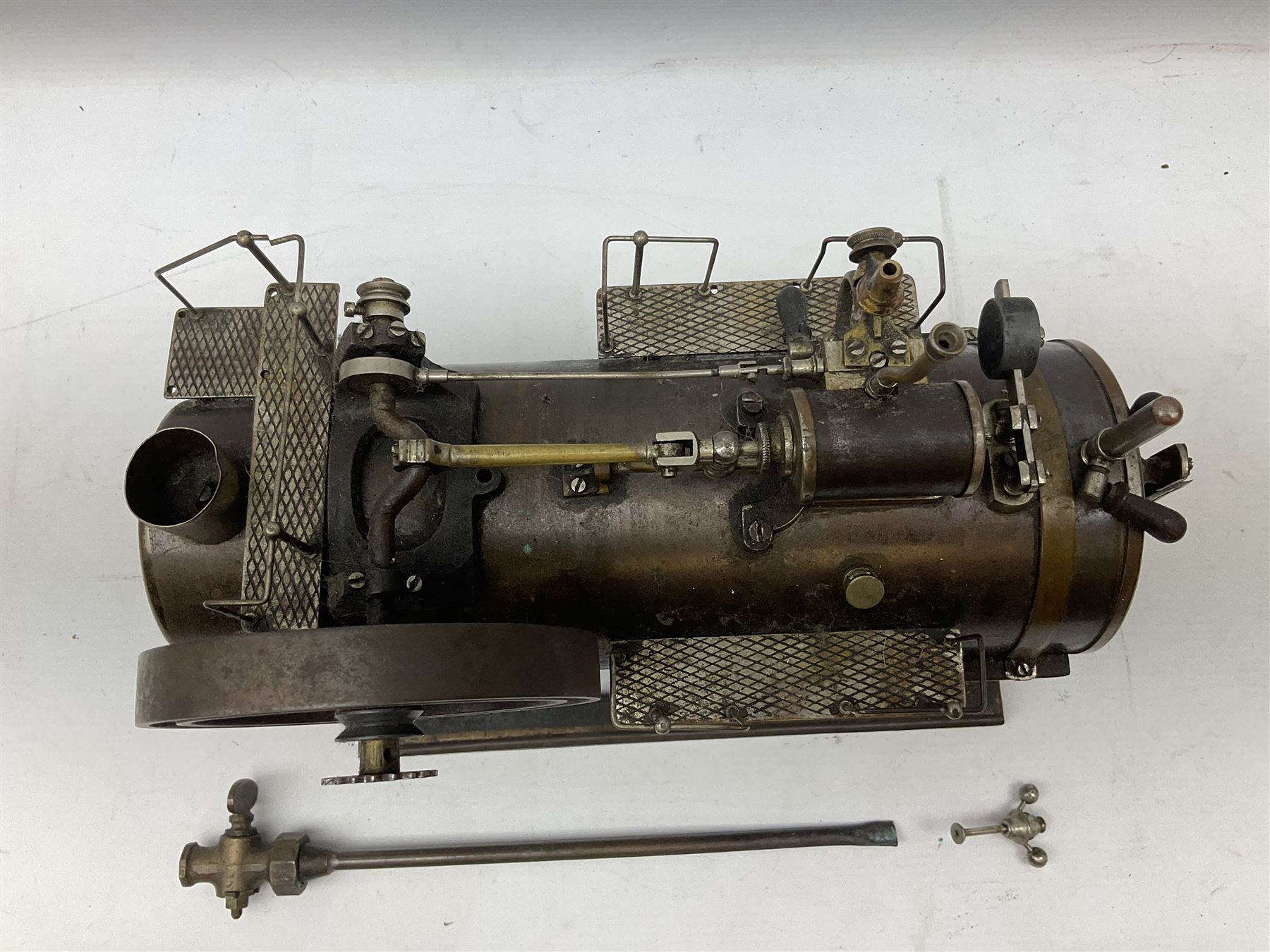 Stationary steam plant, probably early 20th century, the horizontal boiler with water gauge, whistle, safety valve, railed platforms and horizontal drive on top to 11cm flywheel; one cog marked Meccano; on oblong base L32cm