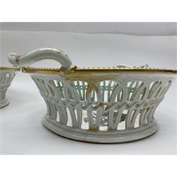 Pair of 19th century German openwork chestnut baskets, with twin handles and scrolling gilt border and star rim, painted to the centre with birds and insects, D22cm 