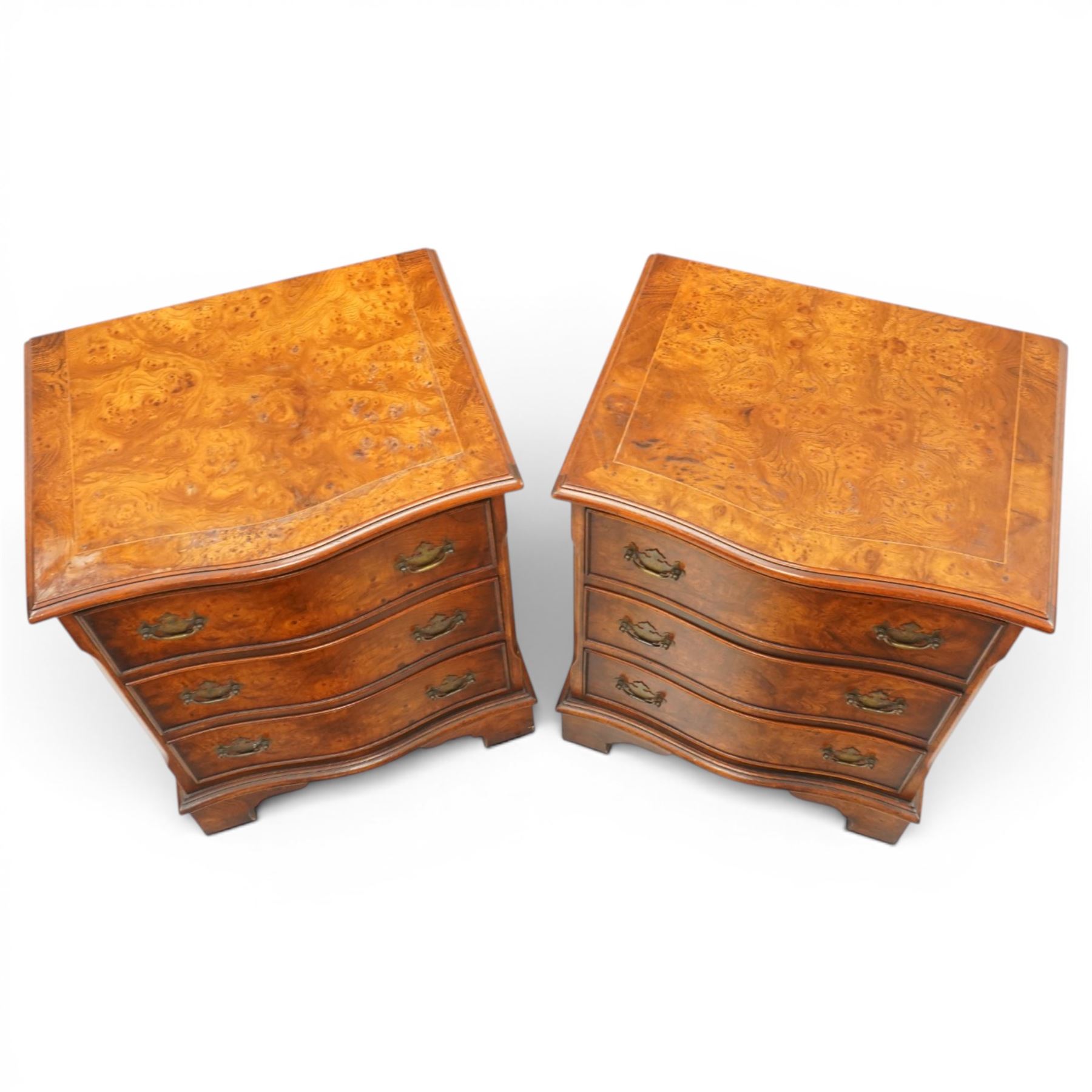 Pair of Georgian design figured elm serpentine bedside chests, moulded top raised on bracket feet