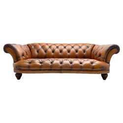 Tetrad - 'Oskar' grande three-seat sofa, Chesterfield shape with rolled arms, upholstered in buttoned tan leather, on turned and reed moulded feet 
