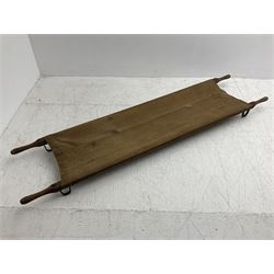 WW1 British casualty stretcher with iron mounted pitch pine sides and canvas base; stamped 'HL1917' and L7 with broad arrow in a triangle L236cm ( reputedly recovered from a barn at Bapaume on The Somme)