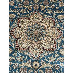 Persian Nain blue and ivory ground rug, wool with silk inlay, overall arabesque design, central medallion surrounded by interlacing and scrolled leafy branches and palmettes, the scrolling border decorated with stylised plant motifs, within guard stripes