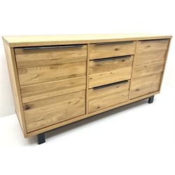 Oak sideboard, one shallow and two deep drawers, flanked by two cupboards revealing fitted interior, metal framed supports 