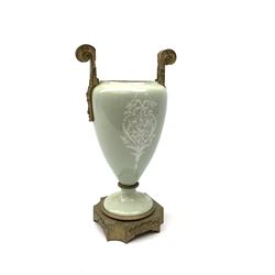 A pate sur pate celadon green vase, of baluster form decorated with a classical female figure to one side, and floral swag with ribbon and musical trophy to the other, with twin gilded scroll handles, and raised upon a gilded base, overall H38.5cm. 
